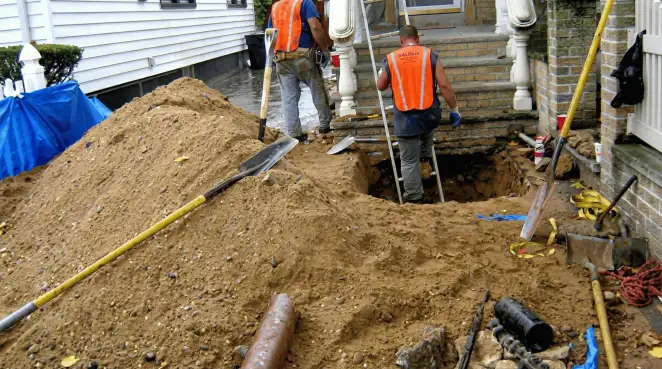 Contractors performing foundation protection and exterior drainage excavation near residential home steps in Colorado Springs, CO